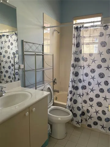 a bathroom with a granite countertop sink toilet a mirror and shower