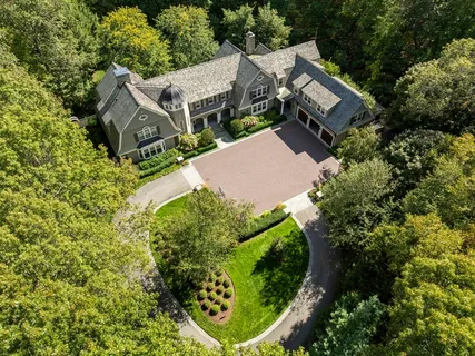 an aerial view of residential house with outdoor space and trees all around