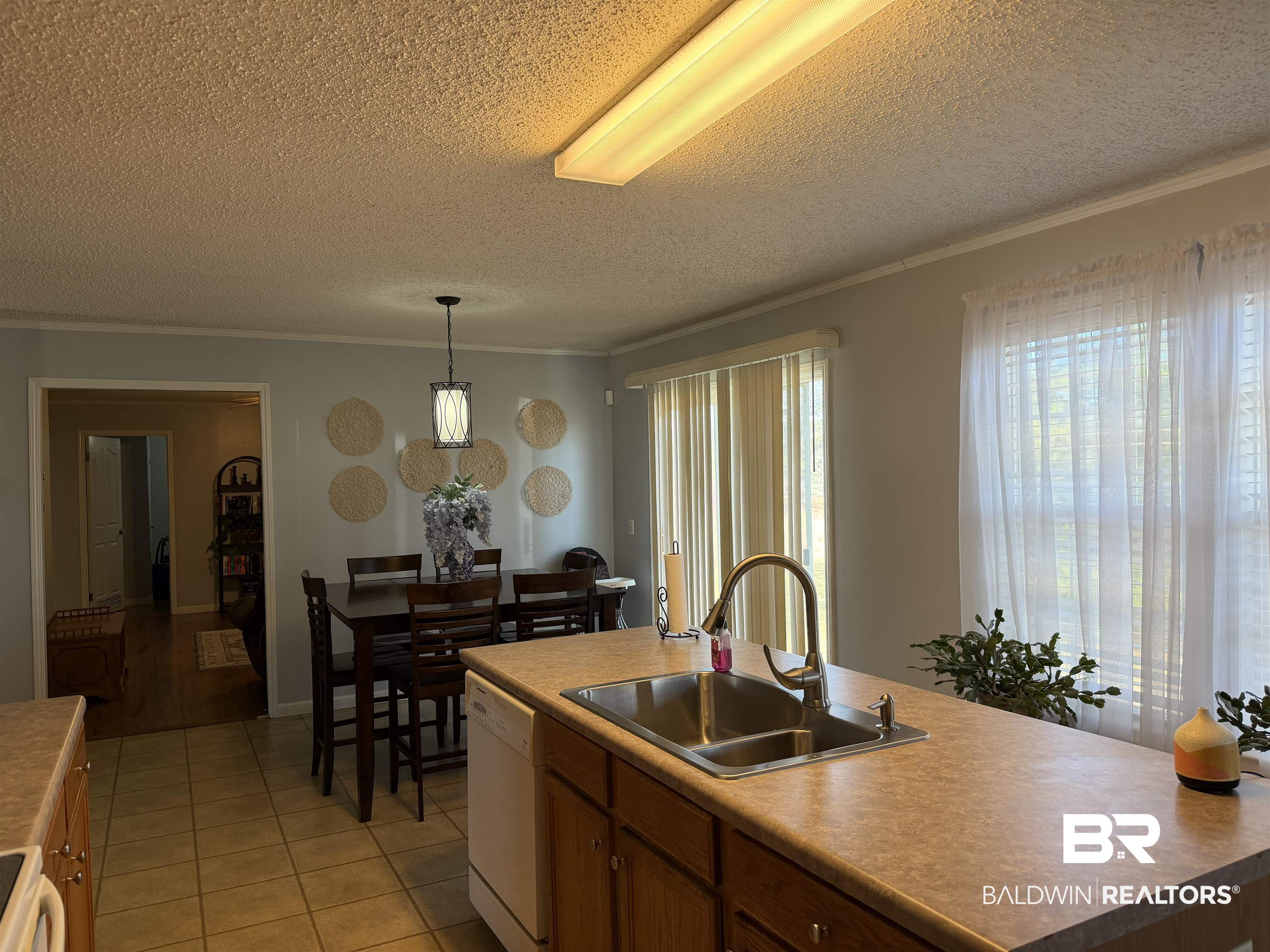 447 Sugar Hill Road Monroeville, AL 36460 - Photo 7 of 27 Kitchen featuring pendant lighting, wood finish cabinetry, light tile patterned floors, white appliances, and a textured ceiling