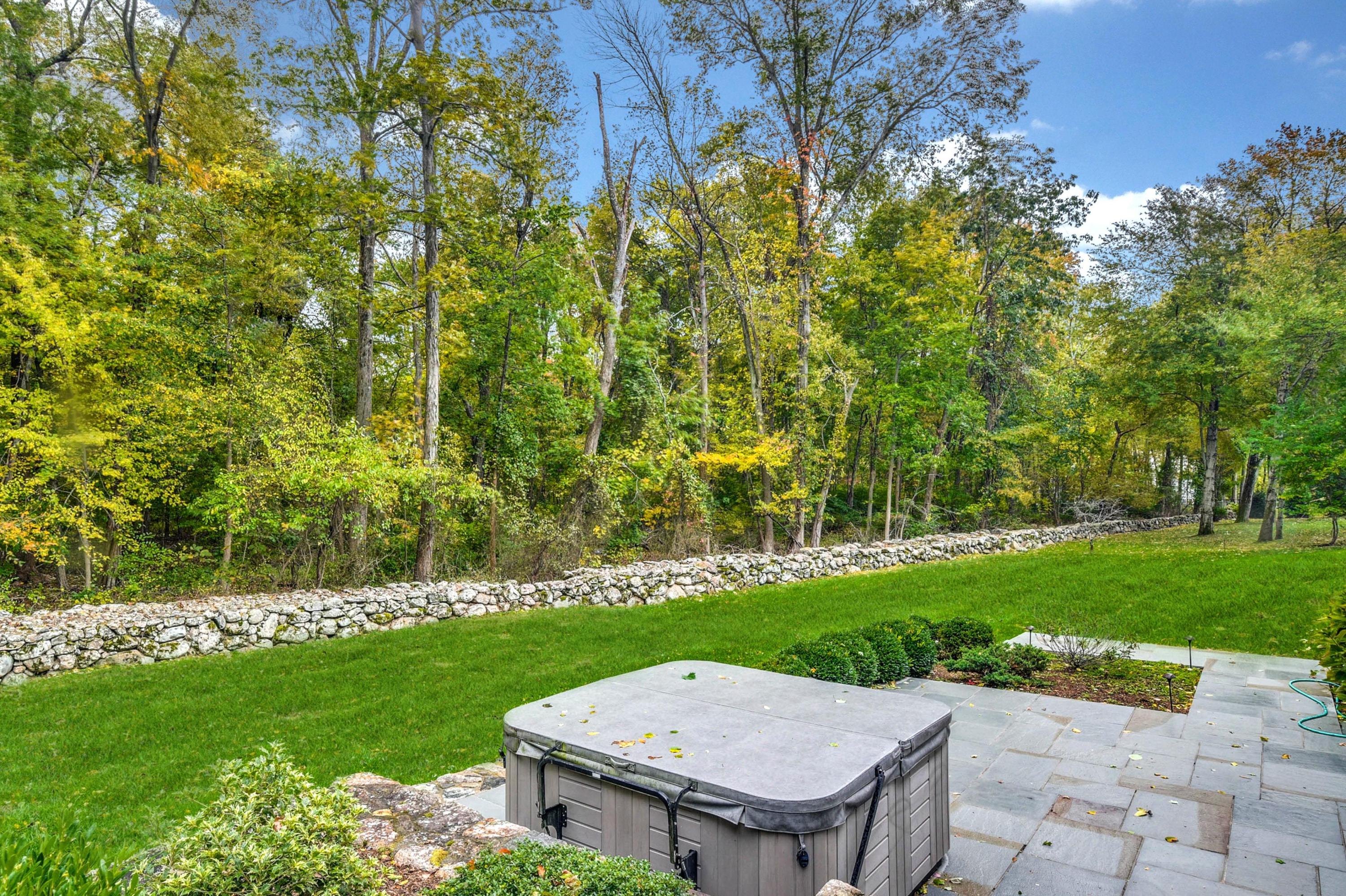 104 Christie Hill Road Darien, CT 06820 - Photo 34 of 38 a view of a backyard with table and chairs with plants and trees