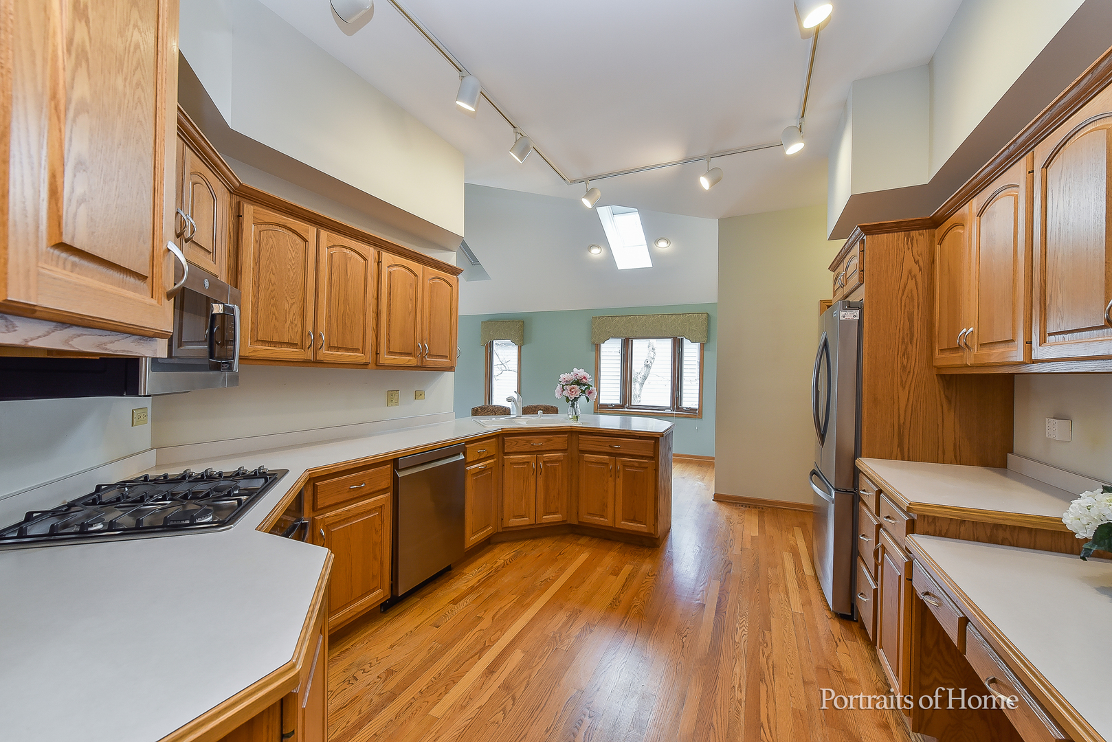 11 Merrimack Court Bolingbrook, IL 60440 - Photo 12 of 46 a kitchen with wooden floors and white appliances