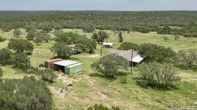 an aerial view of residential houses with outdoor space and trees
