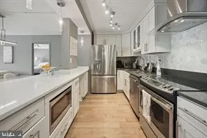 a kitchen with stainless steel appliances a sink stove and cabinets