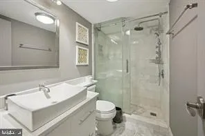 a bathroom with a sink toilet a mirror and shower