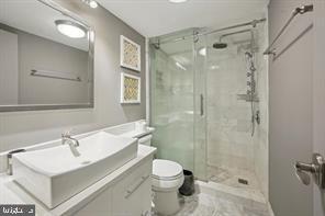 1325 18th Street Northwest, Unit 703 Washington, DC 20036 - Photo 7 of 10 a bathroom with a sink toilet a mirror and shower