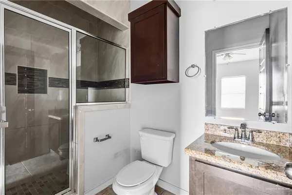 a bathroom with a granite countertop sink toilet and shower