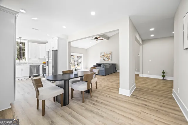 a kitchen with granite countertop white cabinets stainless steel appliances and a sink