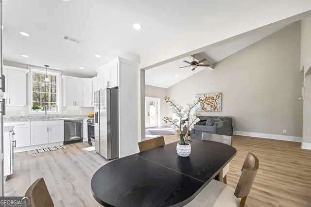 a kitchen with granite countertop white cabinets and a window