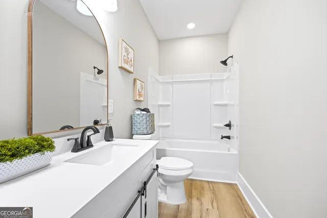 a bathroom with a double vanity sink toilet and a mirror