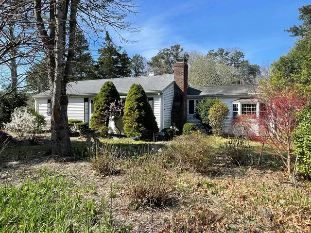a view of a house with a yard and sitting area
