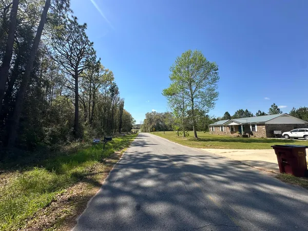 a view of a house with a yard and a trees
