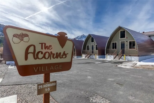 a front view of a residential building with parking and sign board