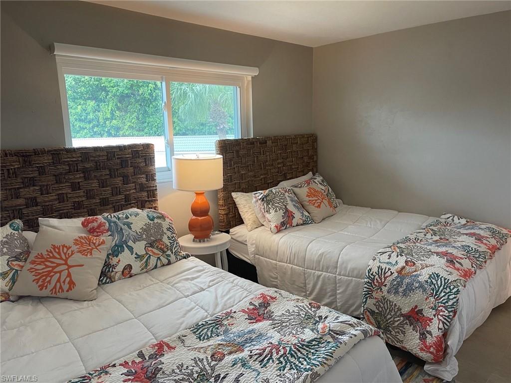 309 Goodlette-Frank Road, Unit 306A Naples, FL 34102 - Photo 14 of 19 a bedroom with two beds and a large window