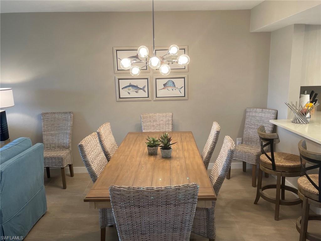 309 Goodlette-Frank Road, Unit 306A Naples, FL 34102 - Photo 5 of 19 a view of a dining room with furniture a chandelier and wooden floor