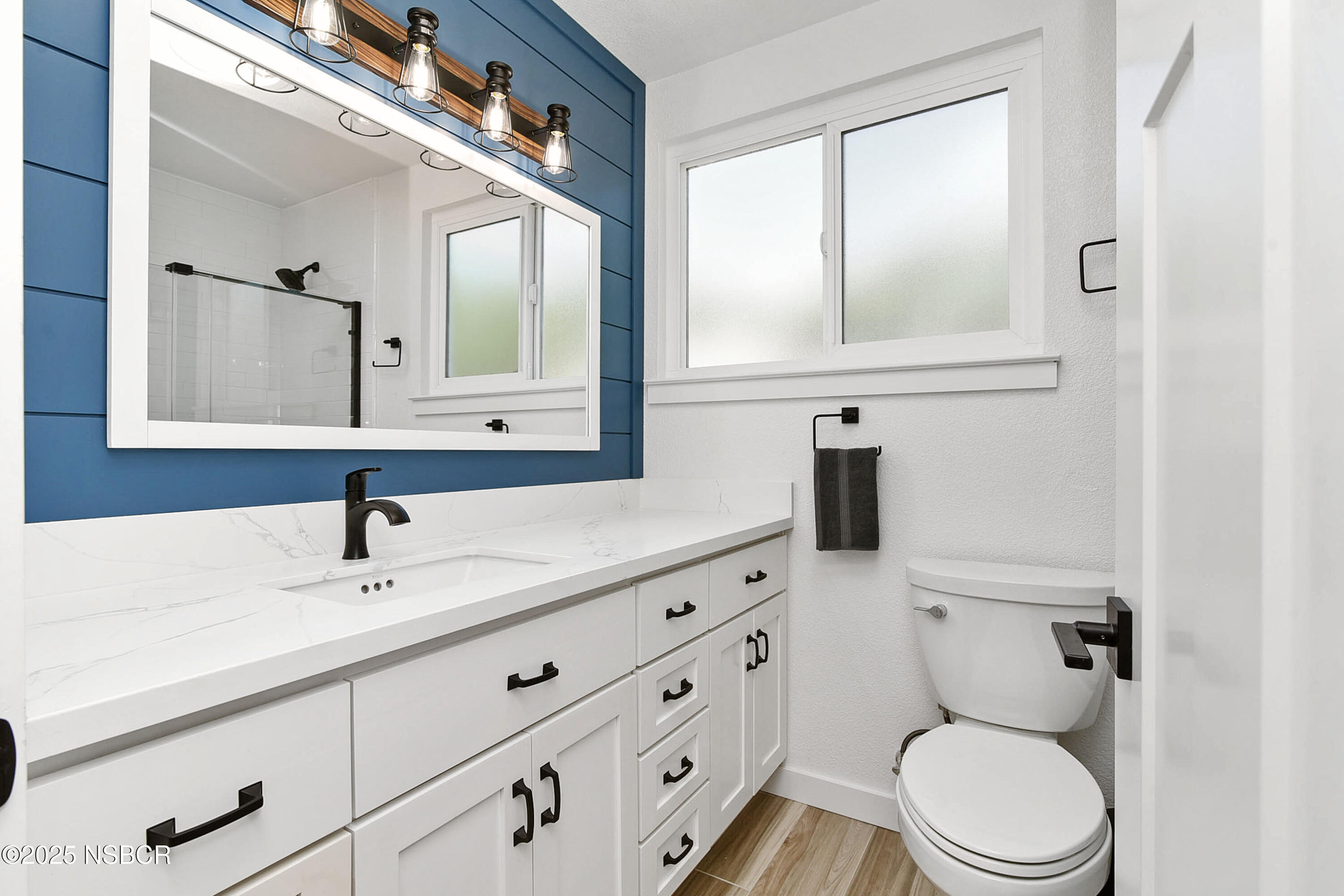 1133 Alden Avenue Lompoc, CA 93436 - Photo 23 of 27 a bathroom with a toilet a sink a mirror and vanity