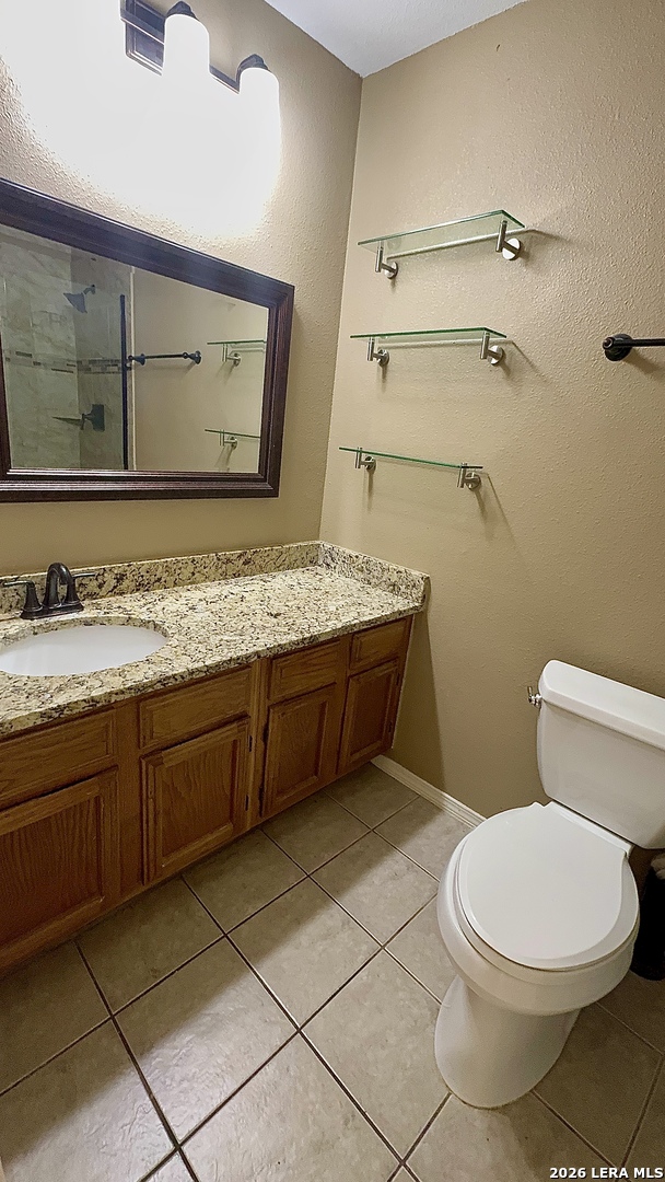 11520 Huebner Road, Unit 205 San Antonio, TX 78230 - Photo 5 of 8 a bathroom with a granite countertop toilet sink and mirror