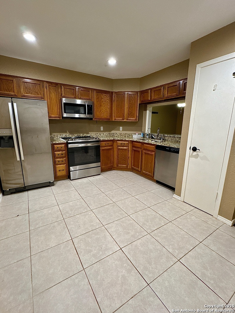 11520 Huebner Road, Unit 205 San Antonio, TX 78230 - Photo 6 of 8 a kitchen with stainless steel appliances granite countertop a refrigerator and a stove top oven