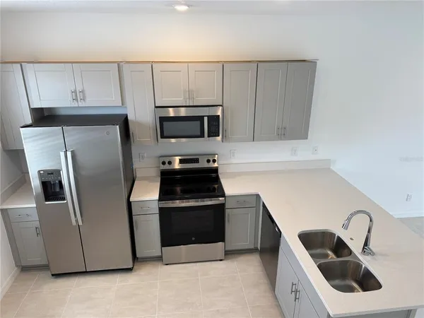 a kitchen with white cabinets and stainless steel appliances