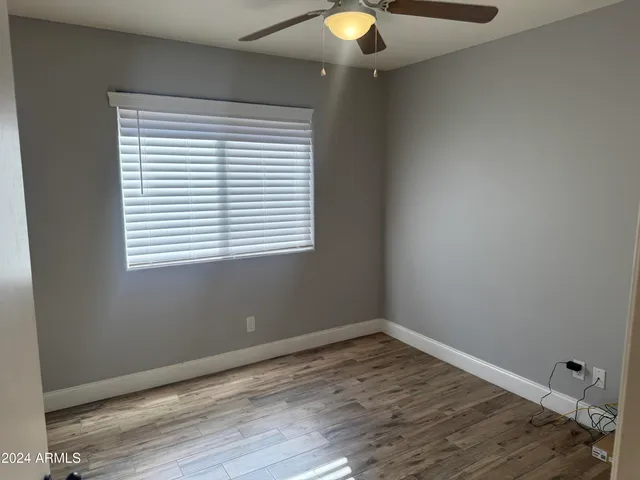 a view of a room with wooden floor and a window