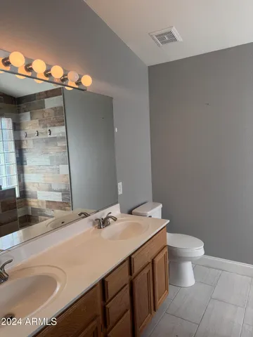 a bathroom with a sink a toilet and mirror