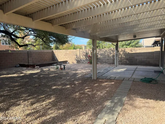 a view of a yard with plants and a large tree