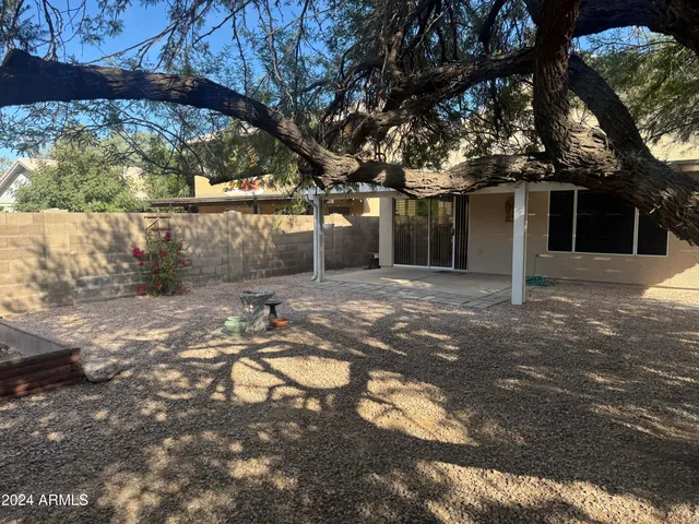a view of a house with backyard and a tree