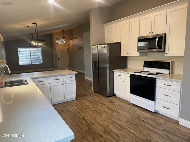 a kitchen with stainless steel appliances a stove a sink and a refrigerator