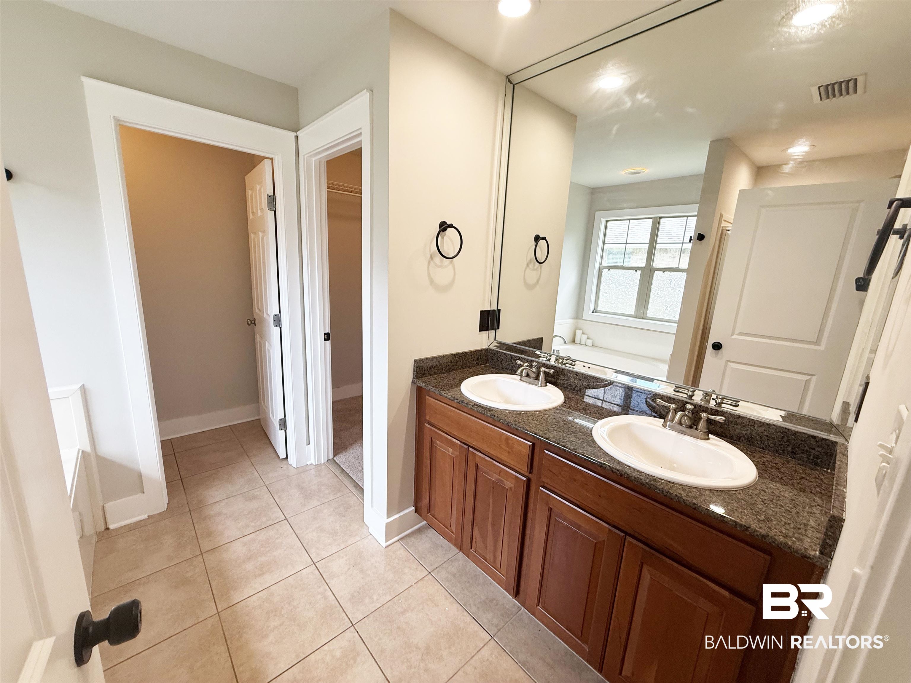 22023 Garland Loop Silverhill, AL 36576 - Photo 17 of 33 Bathroom with a bath, double vanity, tile patterned flooring, and a spacious closet