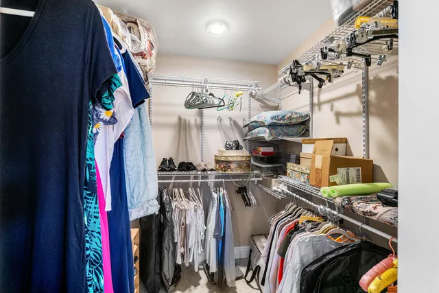 a view of walk in closet with clothes and shoes