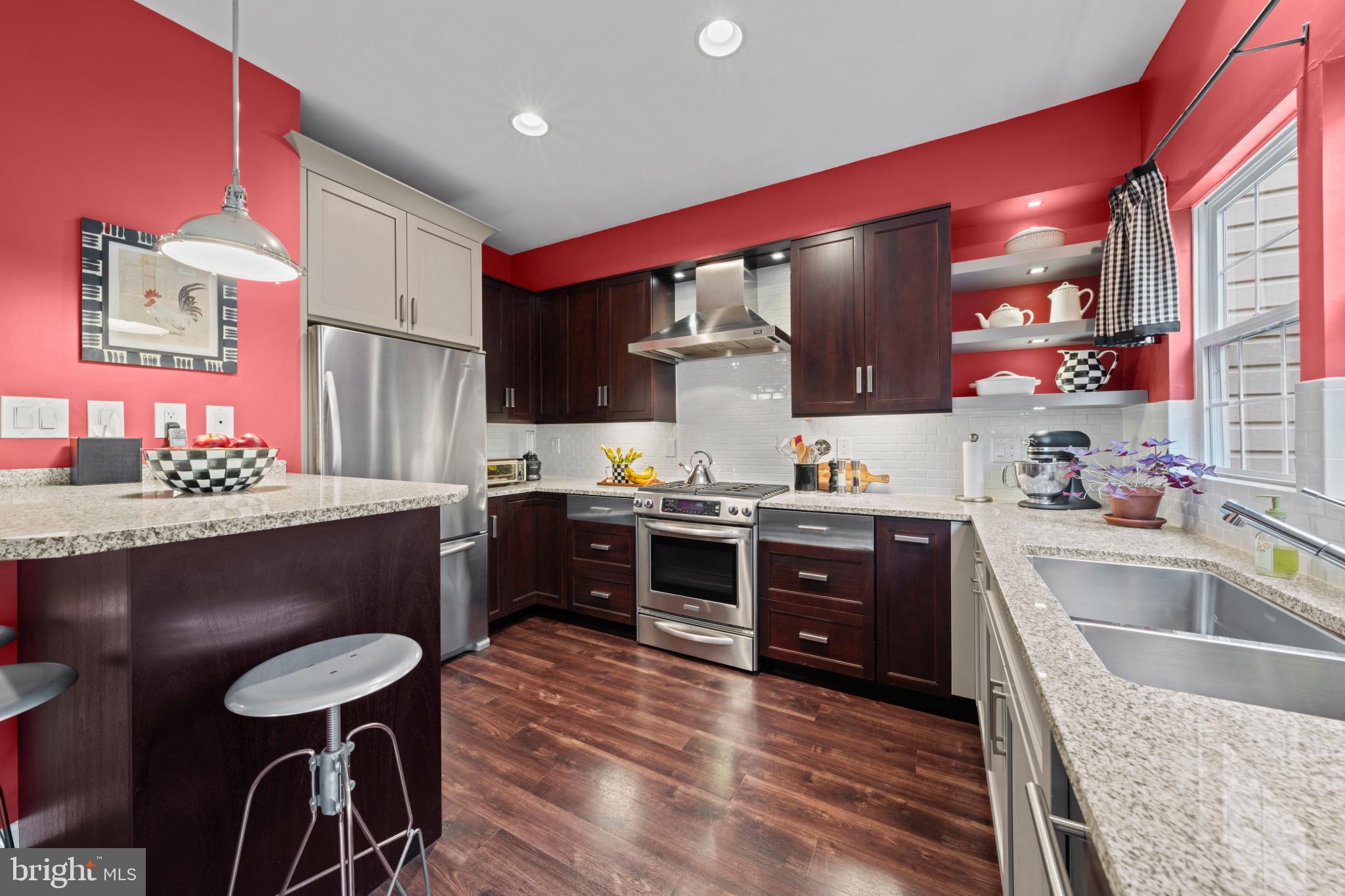 21980 Box Car Square Sterling, VA 20166 - Photo 2 of 38 a kitchen with stainless steel appliances kitchen island granite countertop a sink a stove top oven a counter space and cabinets