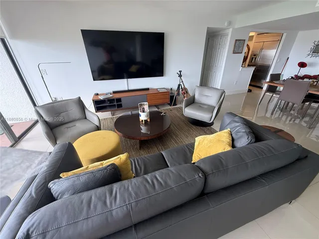 a living room with furniture and a view of kitchen
