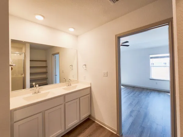 a bathroom with a double vanity sink a mirror and a shower