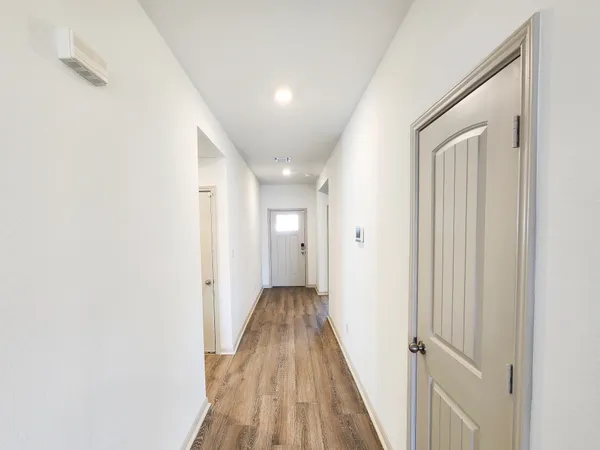 a view of a hallway with wooden floor