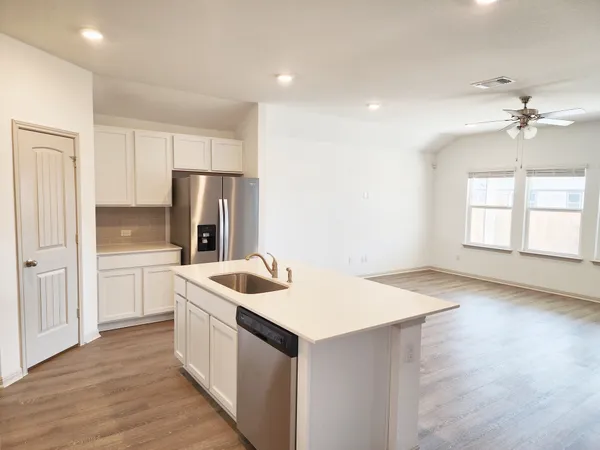 a kitchen that has a sink a refrigerator and window