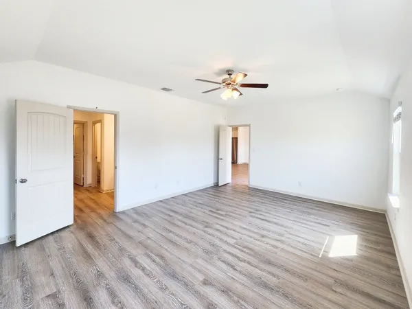 a view of an empty room with wooden floor