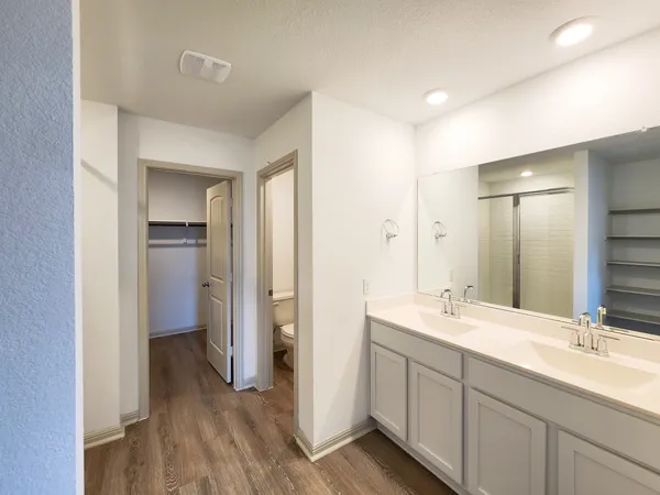 a spacious bathroom with a double vanity sink a mirror and a shower