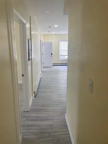 a view of a hallway with wooden floor