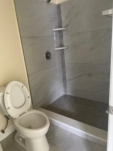 a bathroom with a toilet and a shower