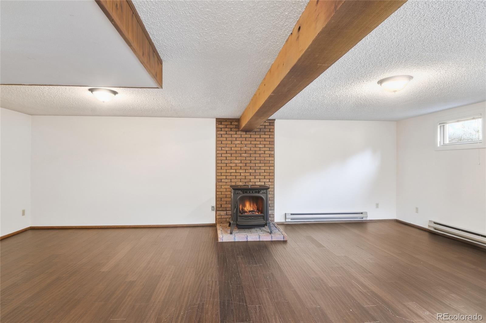 6136 High Drive Morrison, CO 80465 - Photo 16 of 40 an empty room with wooden floor and fireplace