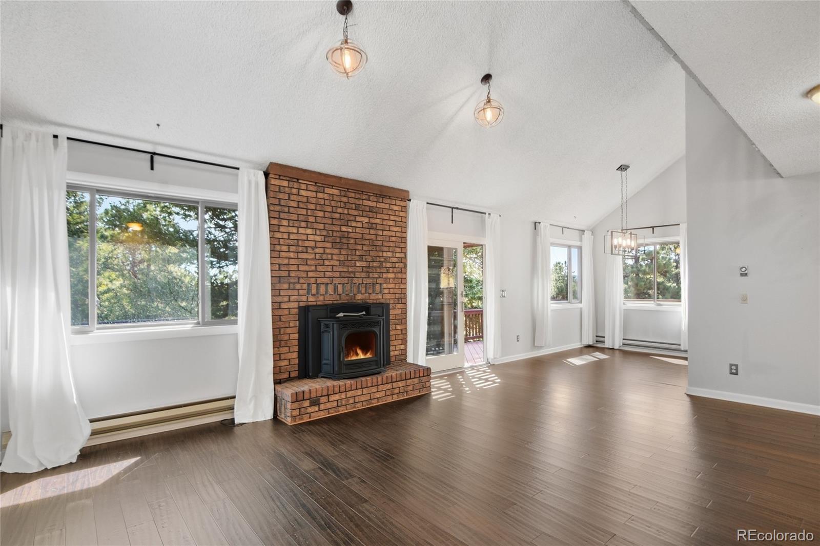 6136 High Drive Morrison, CO 80465 - Photo 2 of 40 a view of an empty room with wooden floor fireplace and a window