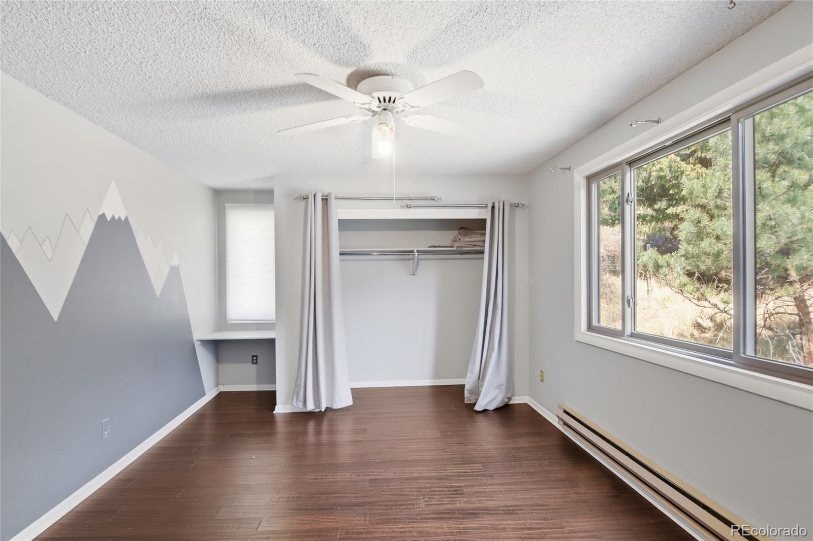 6136 High Drive Morrison, CO 80465 - Photo 21 of 40 an empty room with wooden floor fan and windows