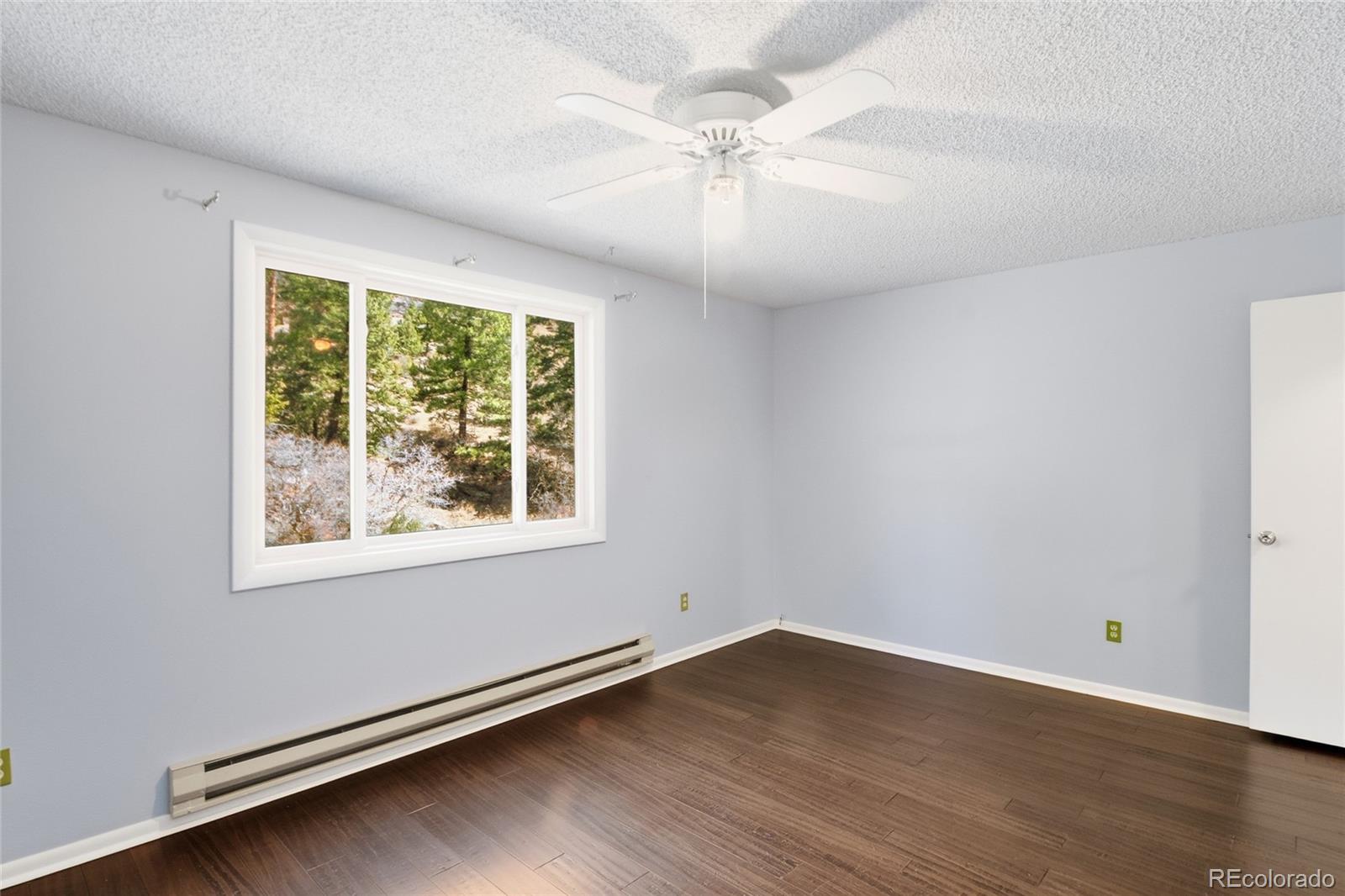 6136 High Drive Morrison, CO 80465 - Photo 22 of 40 an empty room with wooden floor and windows
