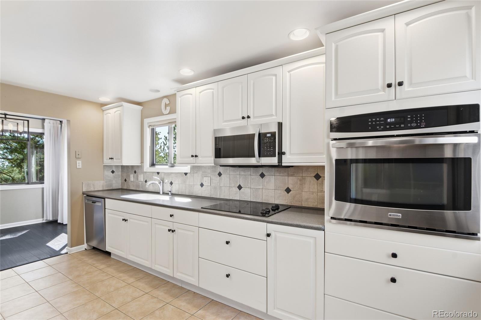 6136 High Drive Morrison, CO 80465 - Photo 5 of 40 a kitchen with stainless steel appliances white cabinets and a stove a oven with white countertops