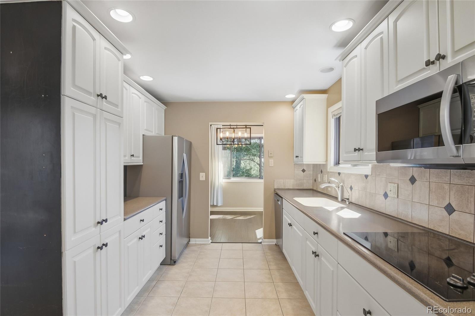 6136 High Drive Morrison, CO 80465 - Photo 6 of 40 a large white kitchen with stainless steel appliances and cabinets