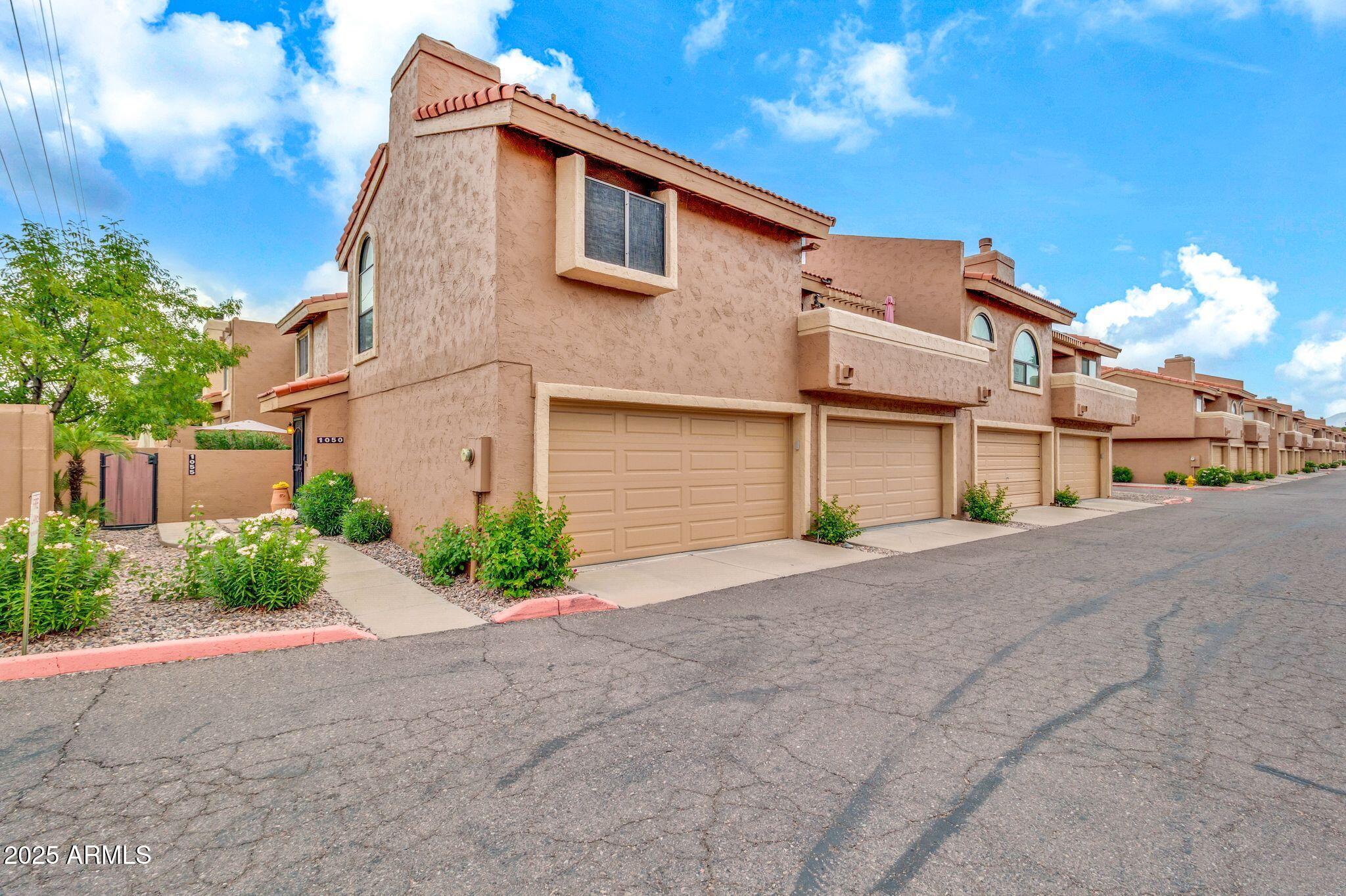 5640 East Bell Road, Unit 1055 Scottsdale, AZ 85254 - Photo 1 of 39 a front view of a house with a yard and garage