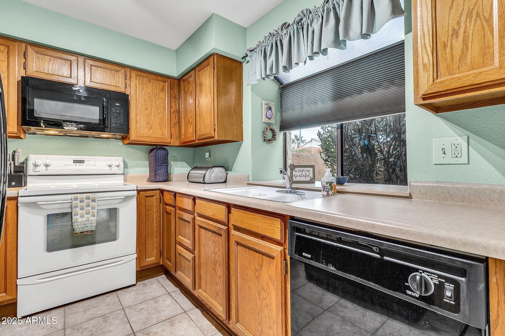 5640 East Bell Road, Unit 1055 Scottsdale, AZ 85254 - Photo 13 of 39 a kitchen with stainless steel appliances a stove sink and microwave