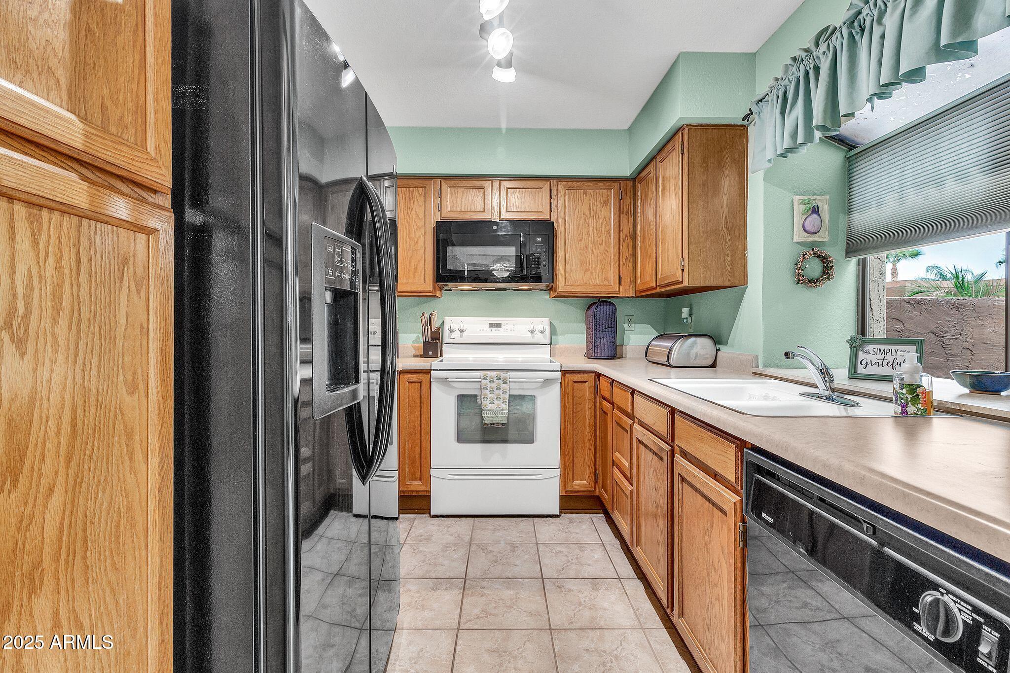 5640 East Bell Road, Unit 1055 Scottsdale, AZ 85254 - Photo 14 of 39 a kitchen with a sink stove and cabinets