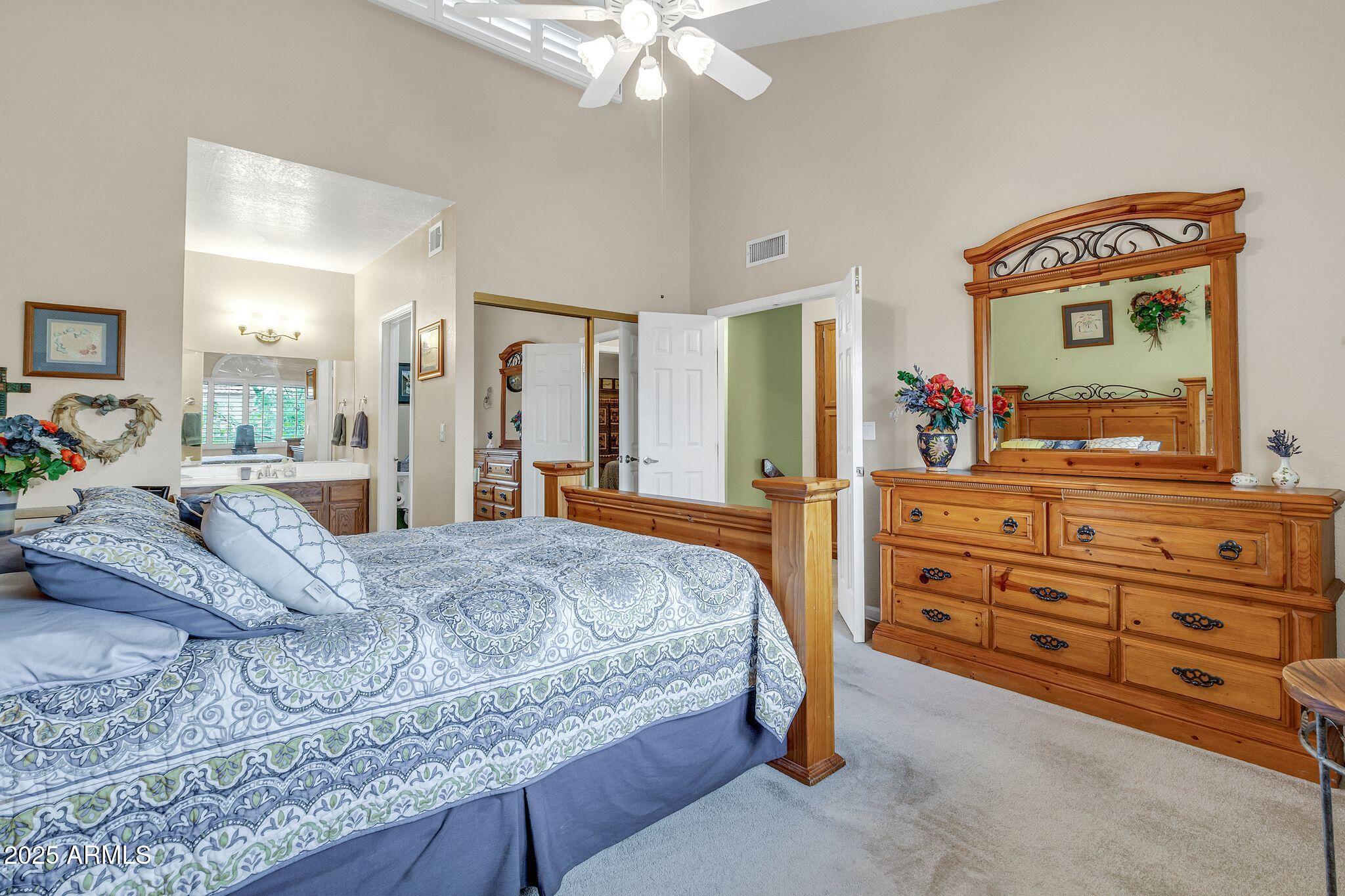 5640 East Bell Road, Unit 1055 Scottsdale, AZ 85254 - Photo 19 of 39 a bedroom with a bed and a large mirror on the dresser