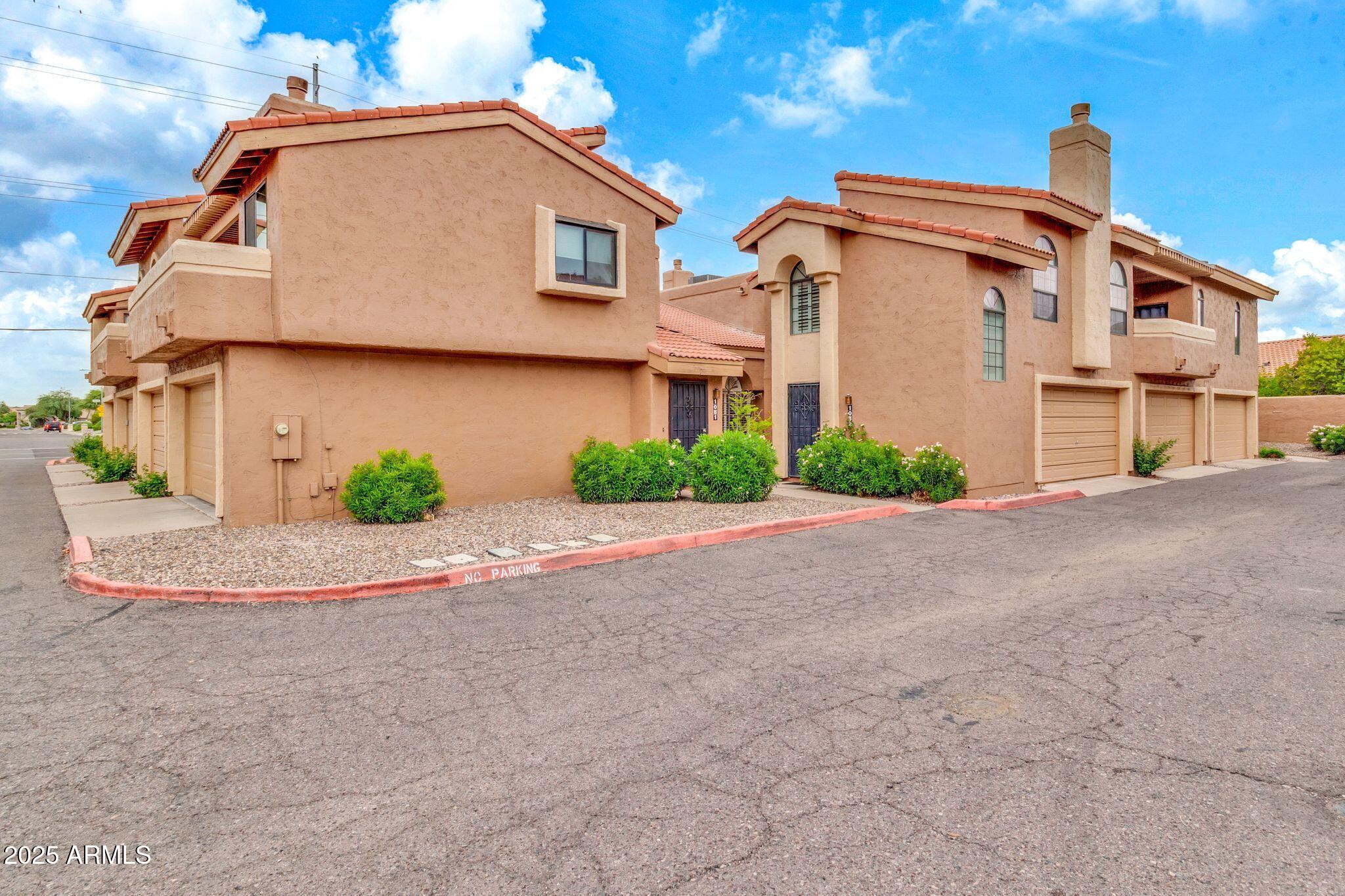5640 East Bell Road, Unit 1055 Scottsdale, AZ 85254 - Photo 34 of 39 a front view of a house with a yard and garage