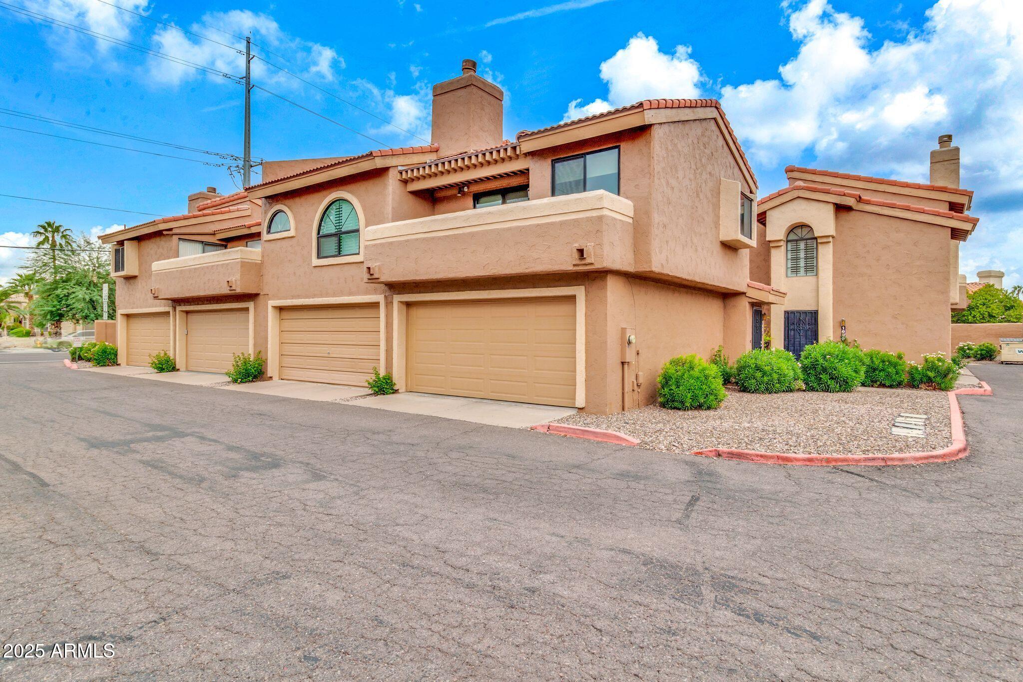 5640 East Bell Road, Unit 1055 Scottsdale, AZ 85254 - Photo 35 of 39 a front view of a house with a yard and garage